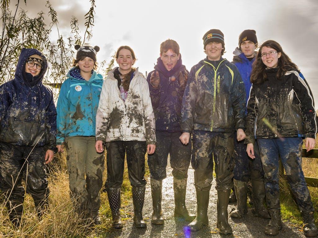 Seven young people on a muddy hike